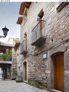 - un bâtiment en pierre avec des balcons sur le côté dans l'établissement Vistas a la Montaña en un Pueblo con Encanto., à El Pueyo de Araguás