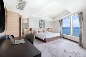 1 dormitorio con 1 cama y escritorio con ordenador portátil en Harbour Grand Kowloon en Hong Kong