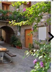 - un bâtiment en pierre avec une porte en bois et un banc dans l'établissement Vistas a la Montaña en un Pueblo con Encanto., à El Pueyo de Araguás