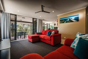 a living room with a red couch and a table at Riverside Holiday Resort Urunga in Urunga