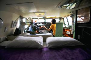 a woman is making beds in a camper van at Woodlyn Park Motel in Waitomo Caves