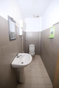 a bathroom with a sink and a toilet at L&C Premium Stay in Kuching