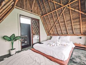 a bedroom with a large bed with a large window at Capila Villa Bali in Canggu