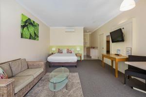 a hotel room with a bed and a couch at Ballina Beach Resort in Ballina