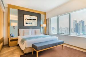 a bedroom with a large bed and a large window at Somerset Riverview Chengdu in Chengdu