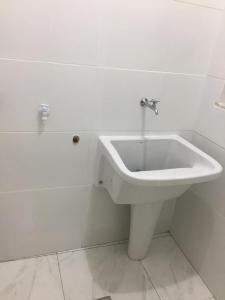 Un baño con un lavabo blanco y un inodoro. en Hospedagem da Rose - Cabo Frio, en Cabo Frío
