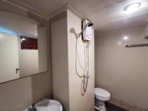 a bathroom with a toilet and a shower in it at Baan Lanna Resort in Chon Buri
