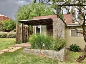 a small house with a stone foundation in a yard at Cabañas Ambay in Merlo