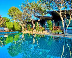 a swimming pool with trees and a house at Family House Zen Boutique Resort in Pai