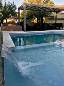 una piscina con una fuente de agua en un patio en Cabañas Ambay en Merlo
