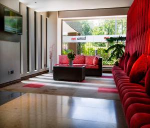 ein Wohnzimmer mit roten Sofas und einem großen Fenster in der Unterkunft Boma Inn Eldoret in Eldoret