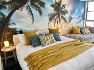 1 dormitorio con 1 cama con un mural de palmeras en Lorne World, en Lorne