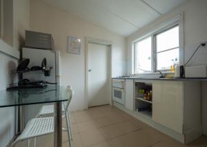a kitchen with a table and a refrigerator at Quiet Private Double Room in Kingsford near UNSW, Randwick Light Railway&Bus G3 - ROOM ONLY in Sydney