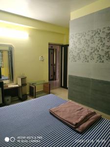 a bedroom with a bed and a sink and a mirror at Zeromiles Hotel Prasant in Digha