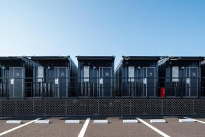 a row of black containers in a parking lot at HOTEL R9 The Yard Ami in Ami