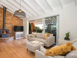 a living room with two couches and a fireplace at Anacapri - Pet Friendly - Opposite Beach - Fireplace in Callala Beach