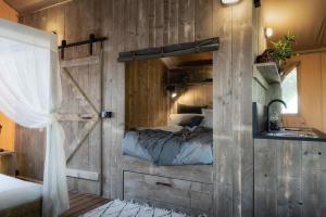 um quarto com uma cama e uma parede de madeira em Castlemaine Gardens Luxury Safari Tents em Castlemaine