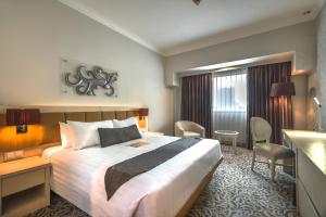 um quarto de hotel com uma cama e uma secretária em Verwood Hotel and Serviced Residence em Surabaya