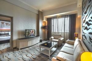 a living room with a couch and a tv in a room at Verwood Hotel and Serviced Residence in Surabaya