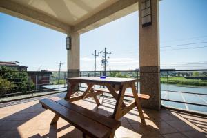 uma mesa de madeira e um banco numa varanda em Lanyang Beach Villa em Wujie