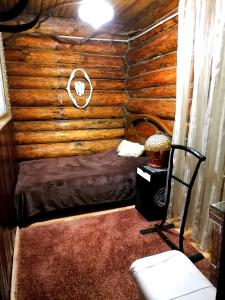 una camera con un letto in una baita di tronchi di Agrousadba Lesnaya Skazka a Belaya
