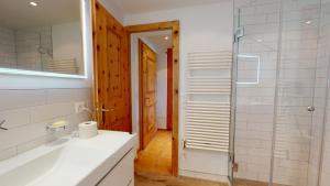 a bathroom with a sink and a glass shower at Abitaziun Sur Sass - Silvaplana Surlej in Surlej +35 photos