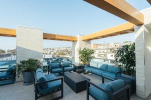 a patio with blue chairs and tables on a roof at H2O Hermosa in Hermosa Beach