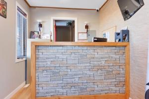 a stone fireplace in a room with a brick wall at Hotel Bethel - Fort MacLeod, AB in Fort Macleod