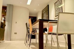 a dining room with a table and chairs at Stylish large cool 3 bed 3 bath Marylebone +AC in London