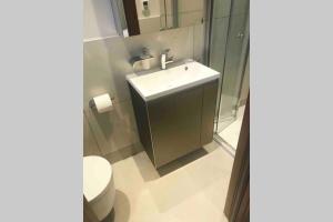 a bathroom with a sink and a toilet at Stylish large cool 3 bed 3 bath Marylebone +AC in London +27 photos