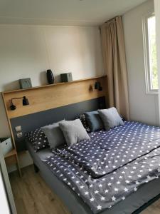 Schlafzimmer mit einem großen Bett mit schwarzweißer Bettwäsche in der Unterkunft Am See 90 in Seekirchen am Wallersee