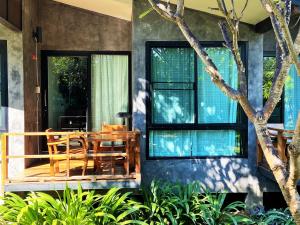a house with a wooden table and chairs on a porch at Family House Zen Boutique Resort in Pai