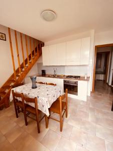 a kitchen with a table and some chairs and a stove at Residence Le Terrazze in Carpegna