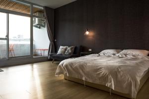 1 dormitorio con cama blanca y sofá en Tainan No 820 en Tainan