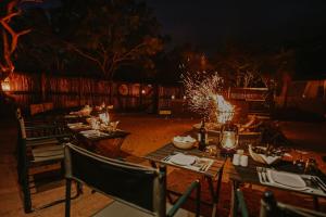 a set of tables and chairs in a yard at night at Phelwana Game Lodge in Hoedspruit