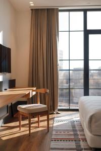 a hotel room with a desk and a bed and a window at NEO Kazan Palace by Tasigo in Kazan