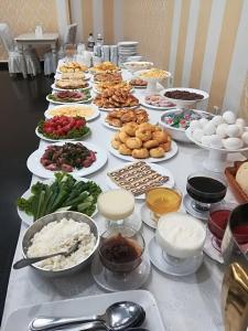 una mesa con muchos platos de comida. en Renion Hotel, en Almaty