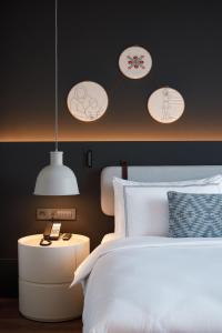 a bedroom with a white bed and pendant lights at NEO Kazan Palace by Tasigo in Kazan