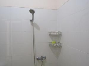 een douche met een douchekop in de badkamer bij Balkondes Bumiharjo (Kampung Dolanan) in Magelang