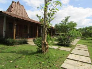 een boom in de tuin van een huis bij Balkondes Bumiharjo (Kampung Dolanan) in Magelang