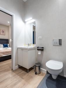 a bathroom with a sink and a toilet and a bed at DeGoya Studios Bucharest Old Town in Bucharest