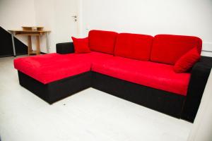 a red couch with red pillows in a room at 2Rooms Semi-luxury Apartment on Pochtovaya 167-A Street in Zaporozhye