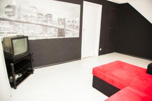 a living room with a red couch and a tv at 2Rooms Semi-luxury Apartment on Pochtovaya 167-A Street in Zaporozhye