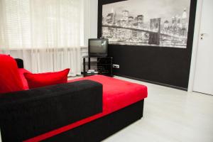 ザポリージャにある2Rooms Semi-luxury Apartment on Pochtovaya 167-A Streetのリビングルーム(赤いソファ、テレビ付)