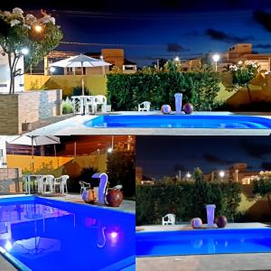 a pool at night with a table and chairs at Pousada Acalanto in Aracaju