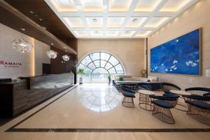 una hall con tavoli e sedie e una grande finestra di Ramada by Wyndham Daejeon a Daejeon