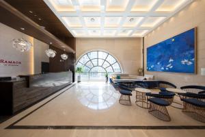 a lobby with tables and chairs and a large window at Ramada by Wyndham Daejeon in Daejeon
