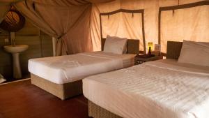 a bedroom with two beds and a tent at vKirirom Pine Resort in Chambok