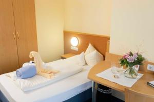 ein Hotelzimmer mit einem Bett mit einem ausgestopften Dinosaurier darauf in der Unterkunft Schmelmer Hof Hotel & Resort in Bad Aibling