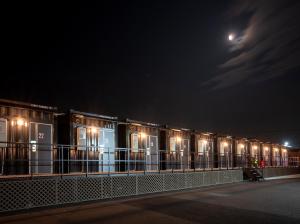 Una fila de vagones de tren de noche con la luna en HOTEL R9 The Yard Isumi, en Chōjamachi